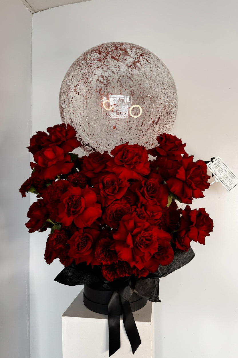 Bouquet of red roses with a personalized balloon in the background