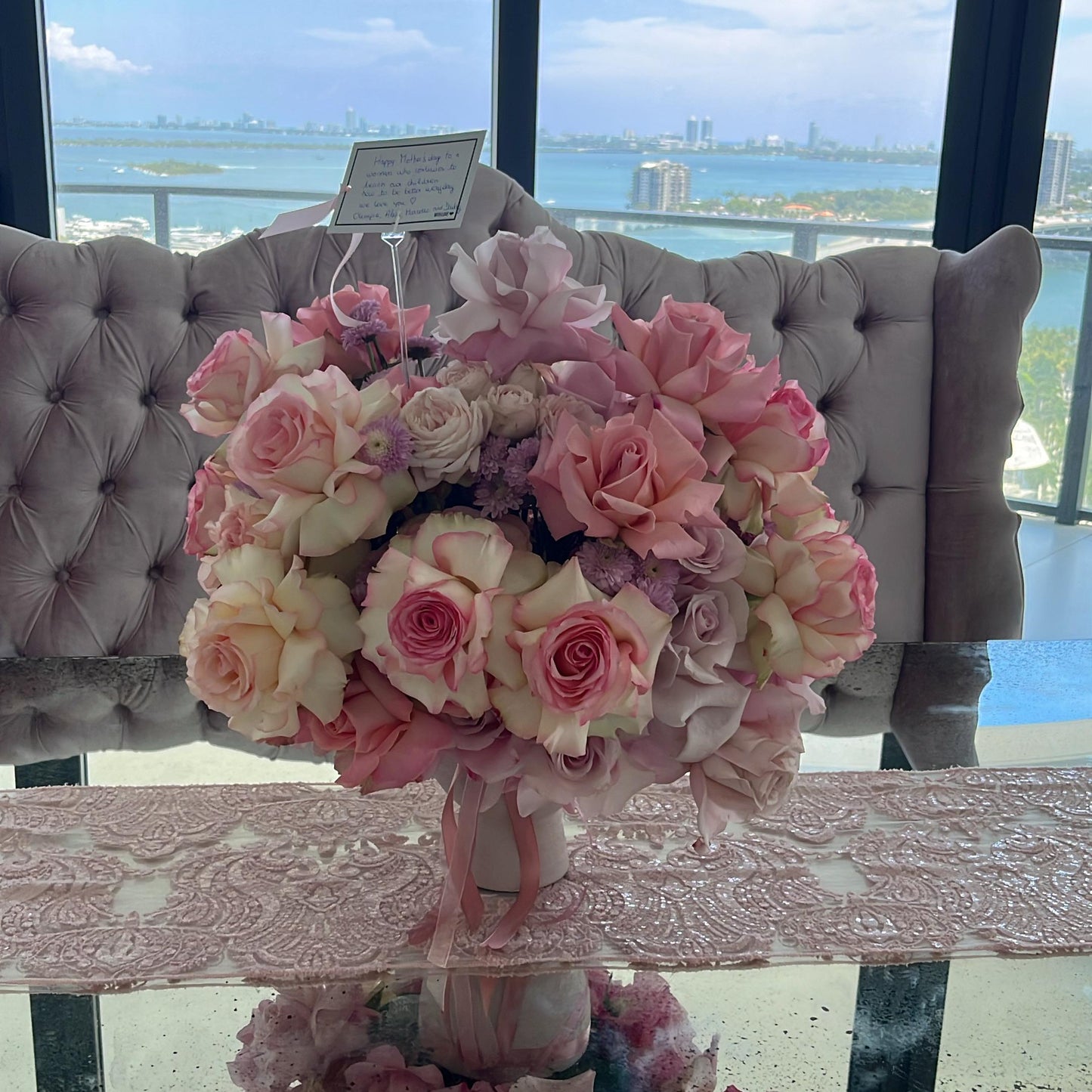 Bouquet of pink and white flowers on a table with a scenic view outside